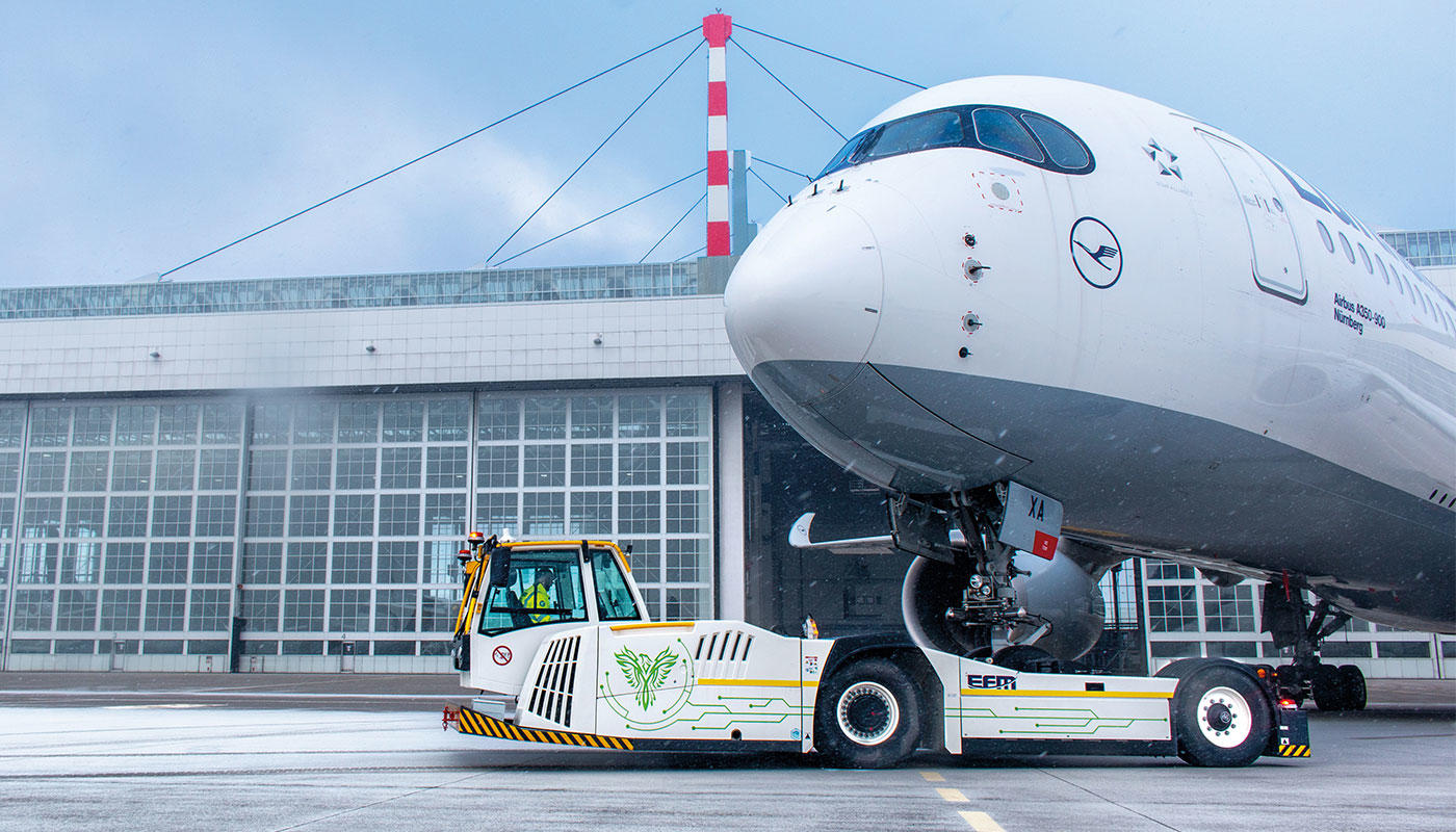 Electric pushback tug towing an aircraft on the airport apron